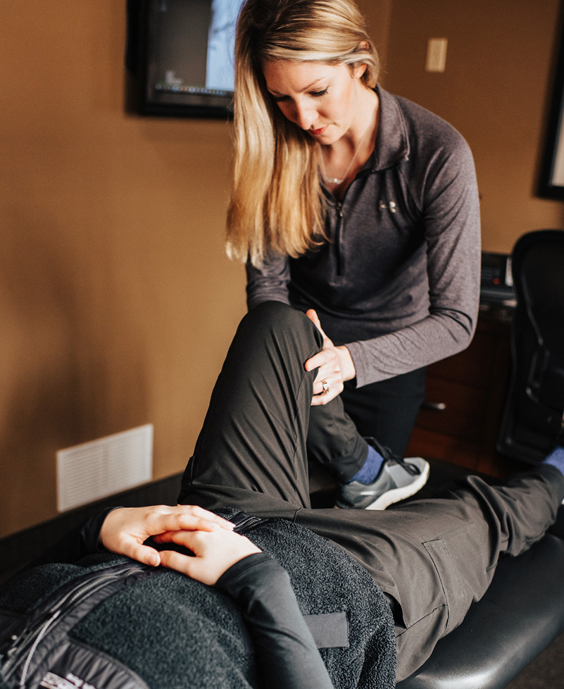 Chiropractor massaging patient leg