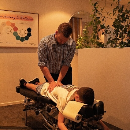 Pukekohe chiropractor Dr Chris adjusting childs back