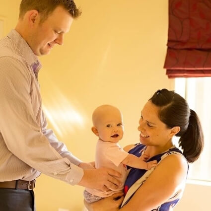 Pukekohe chiropractor Dr Chris adjusting baby with mom holding baby