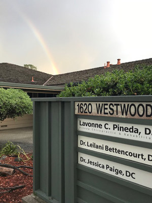 Office sign with rainbow in sky above