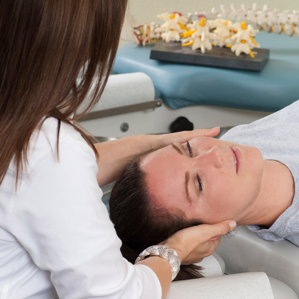 A female chiropractor working on a female patient's neck.