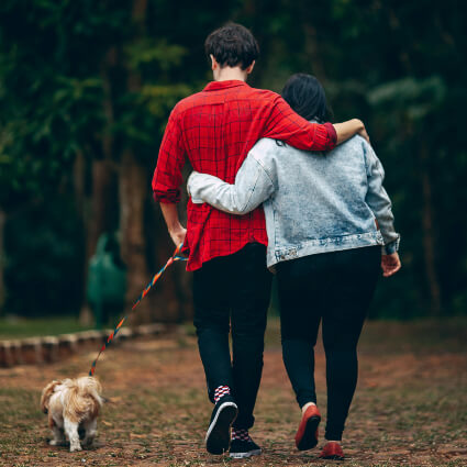 couple walking their dog outdoors