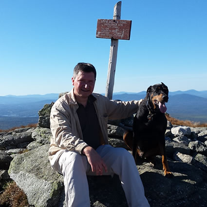 Dr Sawyer with dog on top of the mountain