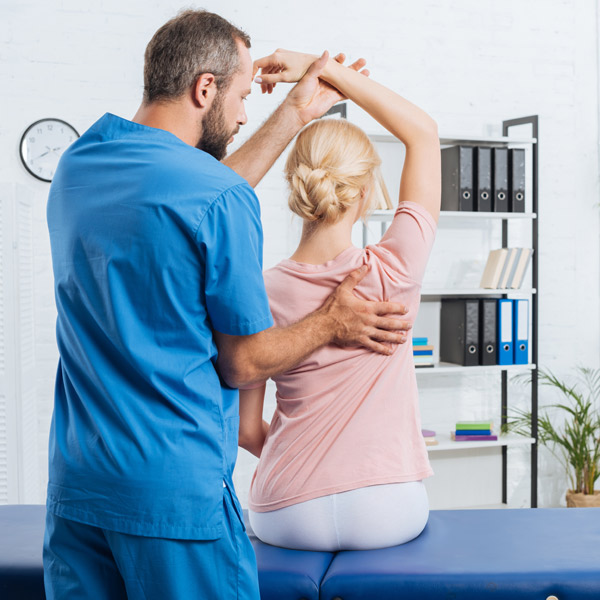 A chiropractor adjusting a woman's arm