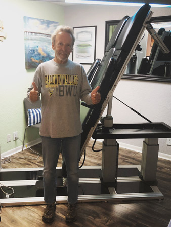 A spinal decompression patient standing in front of the decompression device.