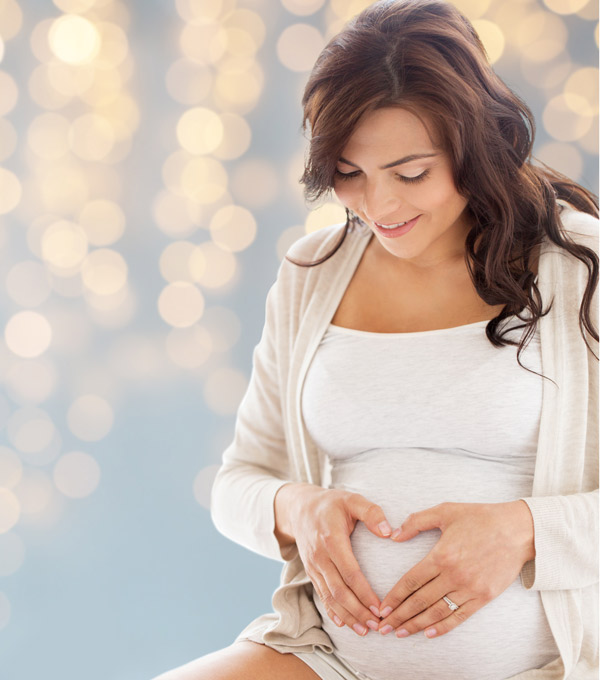 A pregnant woman smiling at her belly