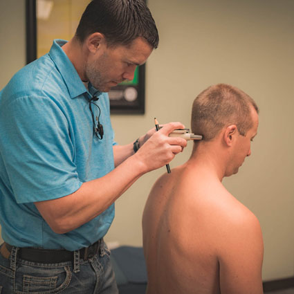 Gonstead technique tool being used on a patient