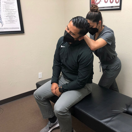 Dr. Lupe adjusting male patients neck