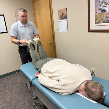 Dr. Matthew adjusting a patient who is lying face down on a chiropractic table.