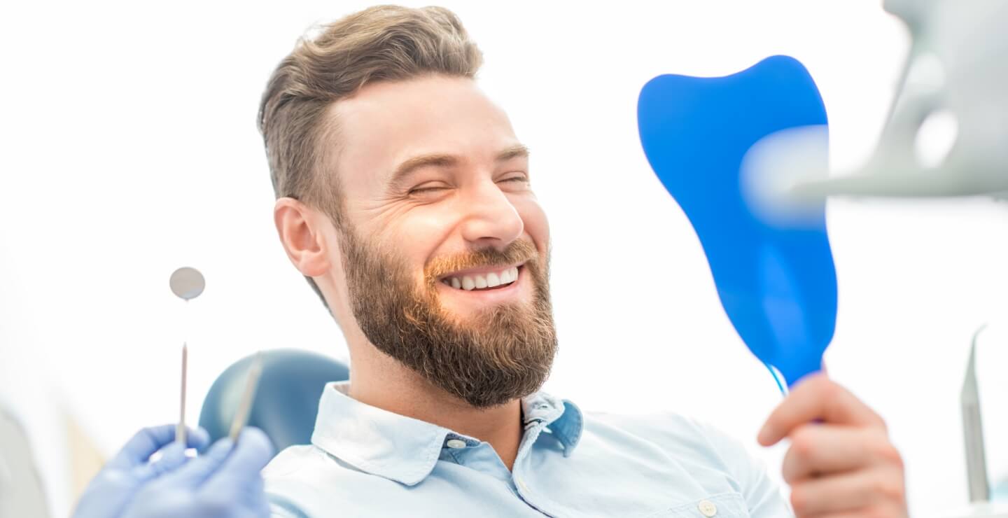 Smiling man looking at mirror