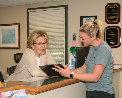 Receptionist discussing paperwork with patient