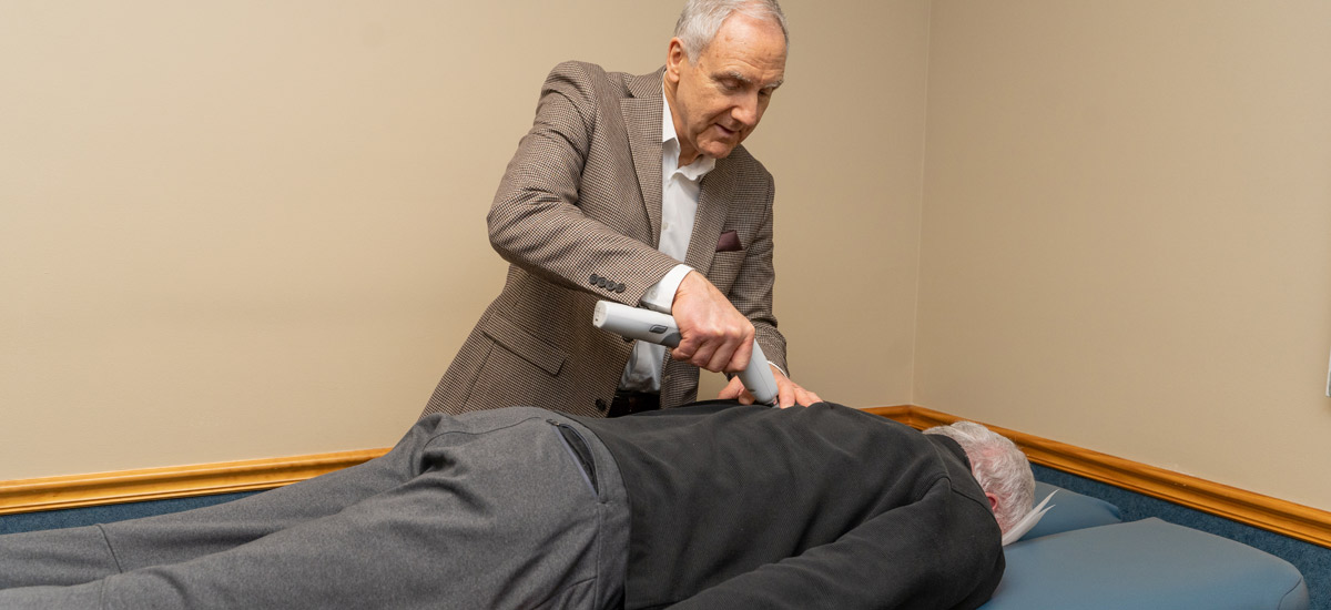 Dr. Bennett adjusting a patient's back with the Activator tool