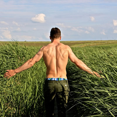 man's back walking in the field