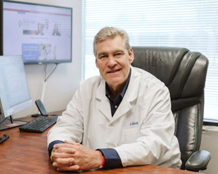 Dr Schmidt at desk smiling