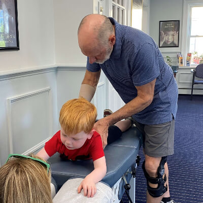 Dr. Bill Byrnes adjusting a child