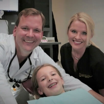 our team smiling with a kid patient
