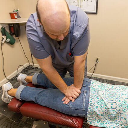 Dr. Cold adjusting woman on table