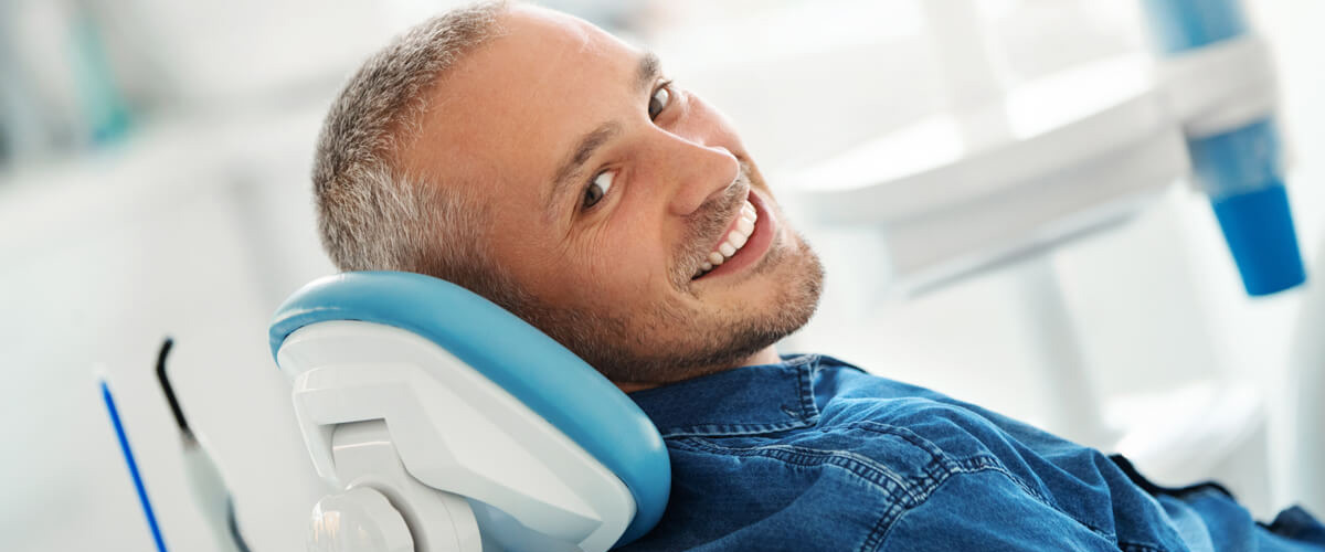 person in dentists chair smiling
