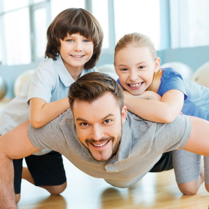 father with kids on his back