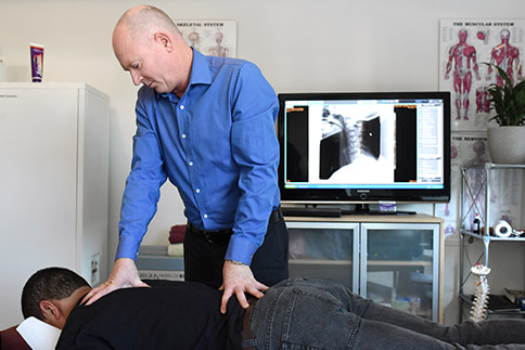 Chiropractor Dr Luke Hennessy adjusting a male patient