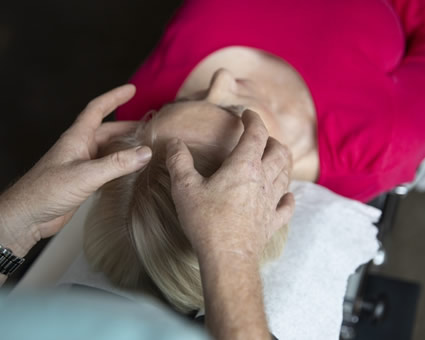 Dr Luke with hands on patients head