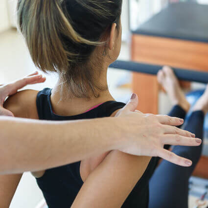 woman-in-black-tanktop-being-assisted-by-therapist-stretching-shoulders-sq