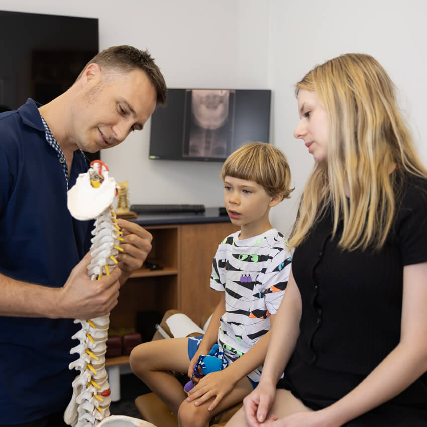 Doctor showing child spine model