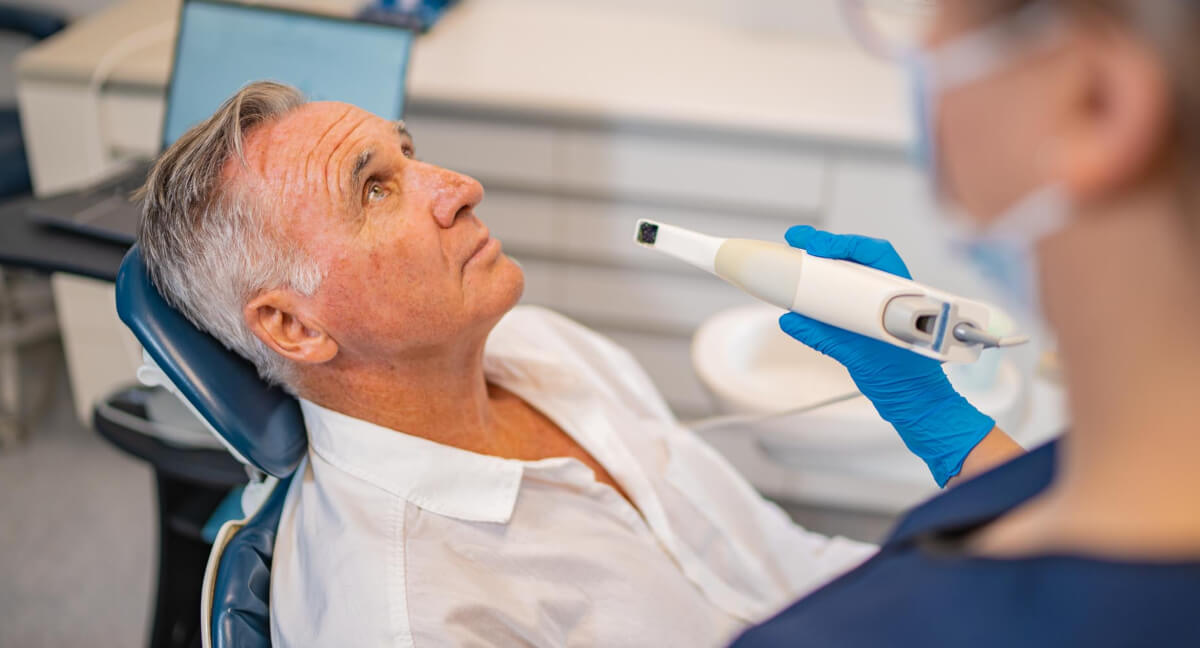 Dental assistant getting a patient ready for an oral scan
