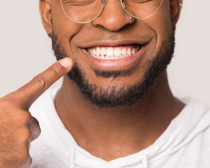 Smiling man pointing at his mouth