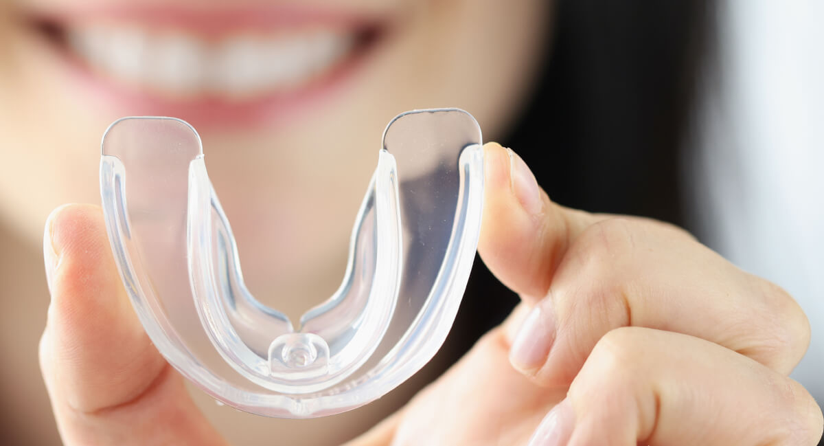 Woman holding a mouthguard