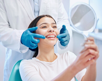 Woman in dental chair looking at mirror