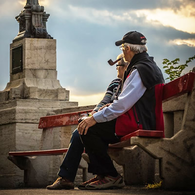 old couple sitting on park bench
