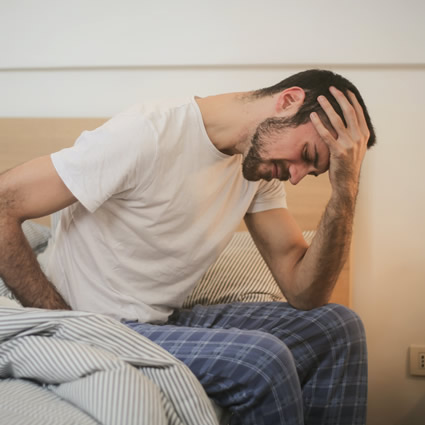 Man with headache on bed