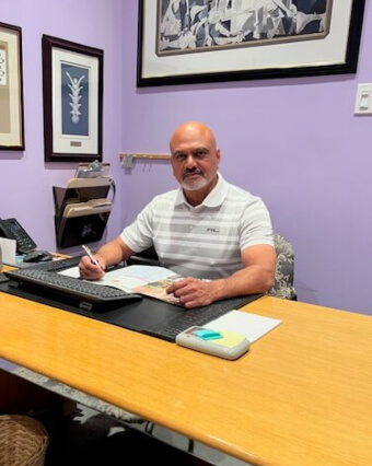 Dr. Gill of City Centre Chiropractic sitting at desk