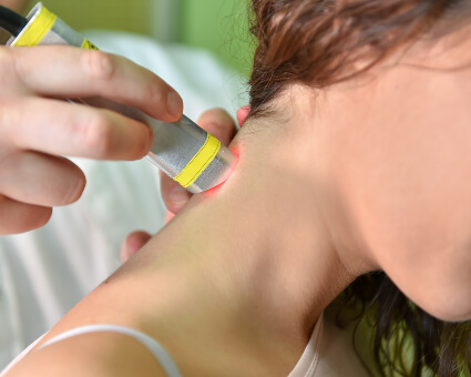 Female patient laser therapy on neck