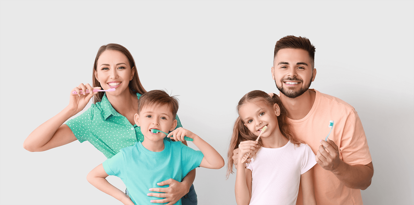 Family of four holding toothbrush