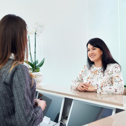 Female patient checking in at reception