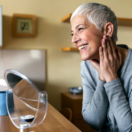 Smiling woman looking at self in mirror