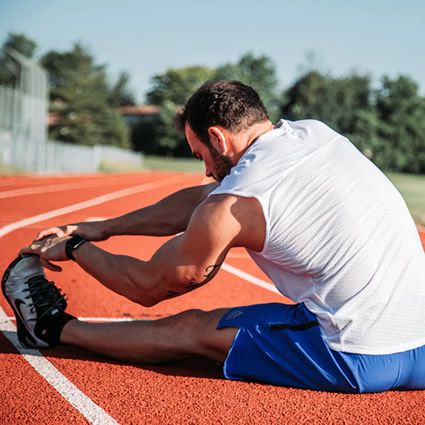athlete stretching leg on track