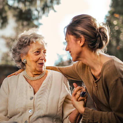 old woman and daughter holding hands smiling