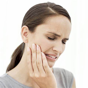 Woman holding her jaw in pain