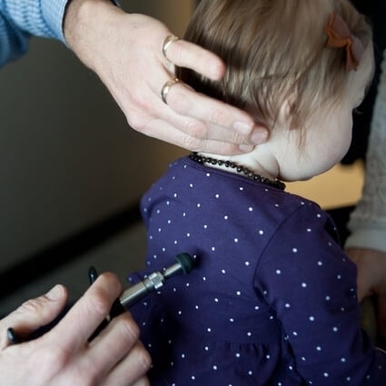 child having neck back adjusted at All Seasons Chiropractic with tool