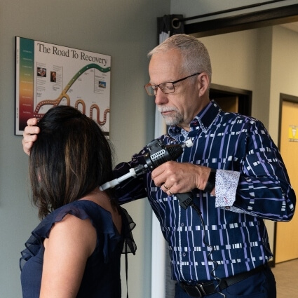 Dr Trevor adjusting patients back with tool