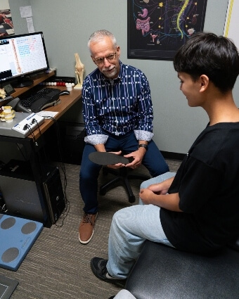 Steinbach chiropractor Dr. Trevor explaining orthotics to patient