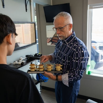 Steinbach chiropractor Dr Trevor showing patient a spine model