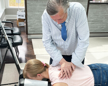 Chiropractor adjusting patient's upper-back