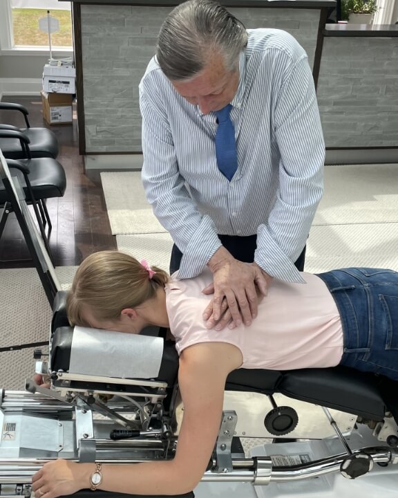 Moore Chiropractic Group chiropractor adjusting patient's back