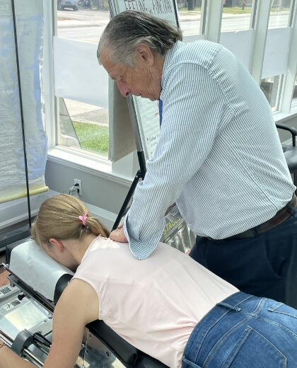 Aurora chiropractor treating a female patient with Chiropractic Care