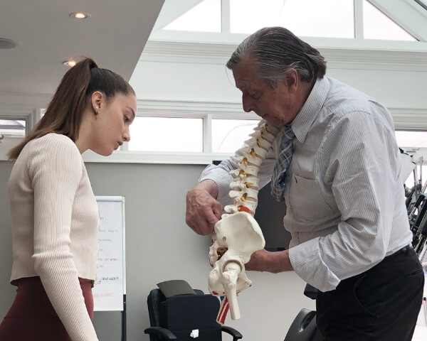 Aurora chiropractor discussing spine model with patient