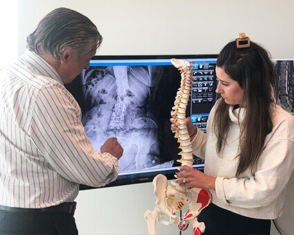 Aurora chiropractor discussing x-ray with patient